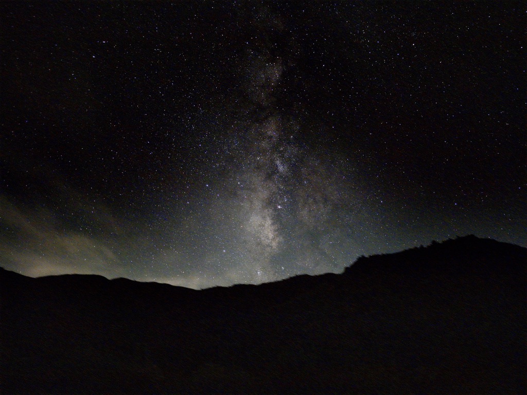 The Milky Way above a dark mountain ridge